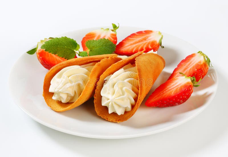 Cone-shaped gingerbread cookies with whipped cream and strawberries