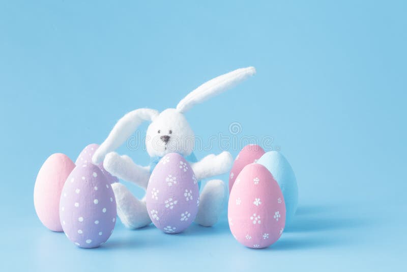Conejo con los huevos de Pascua en azul imagen de archivo Conejo con los huevos de Pascua en azul imagen de archivo