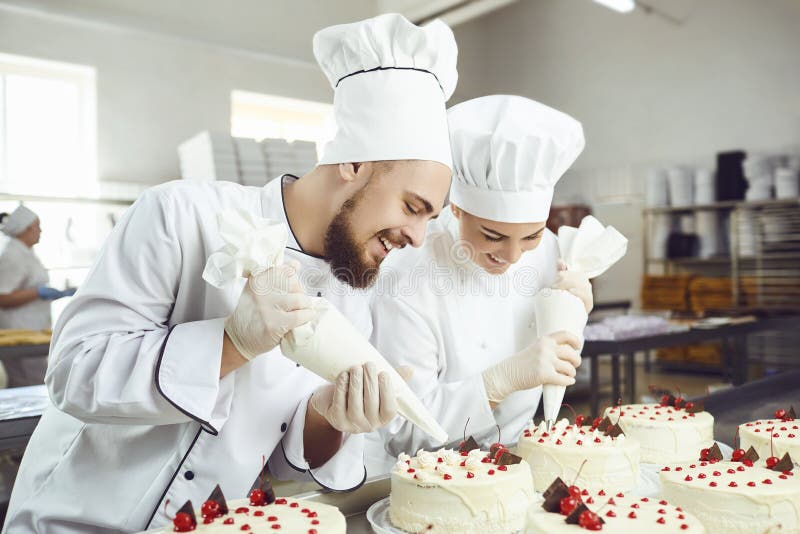 A confectioners squeezes liquid cream from a pastry bag.