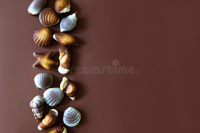 Confeitos sortidos do chocolate no fundo marrom fotos de stock Confeitos sortidos do chocolate no fundo marrom fotos de stock