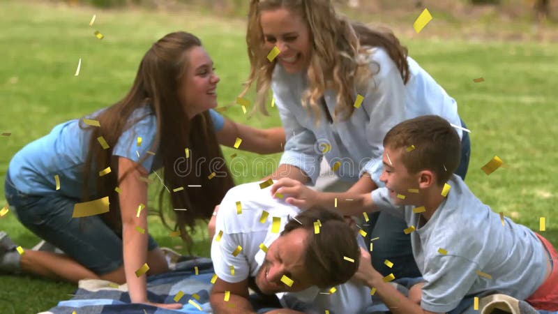 Confetti animatie peste familie joc și râs pe pătură de picnic în parc stock video