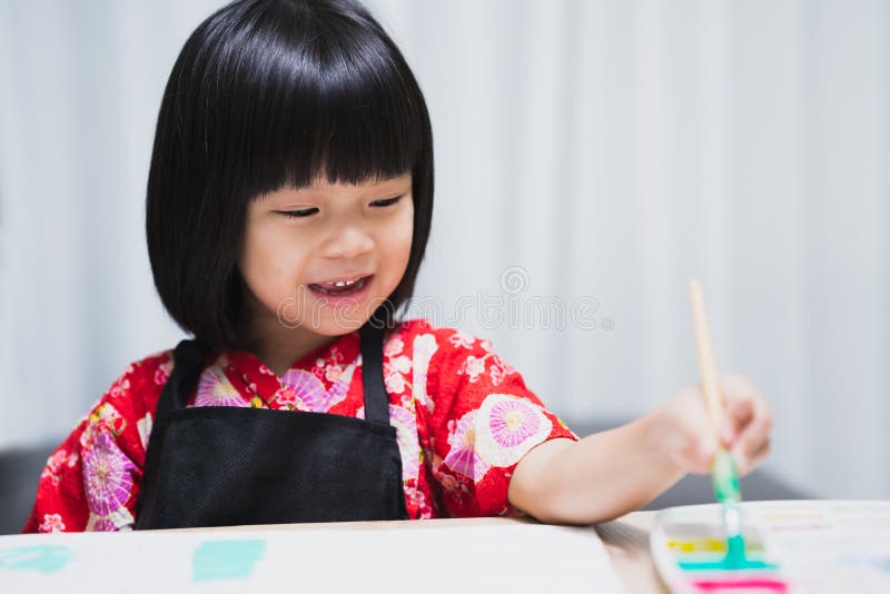 Confidence positivity and freedom be creative concept. Portrait of adorable Asian little child girl holding a paintbrush and doing