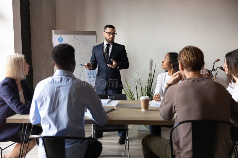 Confident businessman giving flip chart presentation at corporate meeting stock photos Confident businessman giving flip chart presentation at corporate meeting stock photos