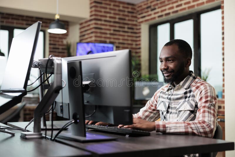 Confident creative office worker sitting at computer in office workspace while developing digital art. royalty free stock photos