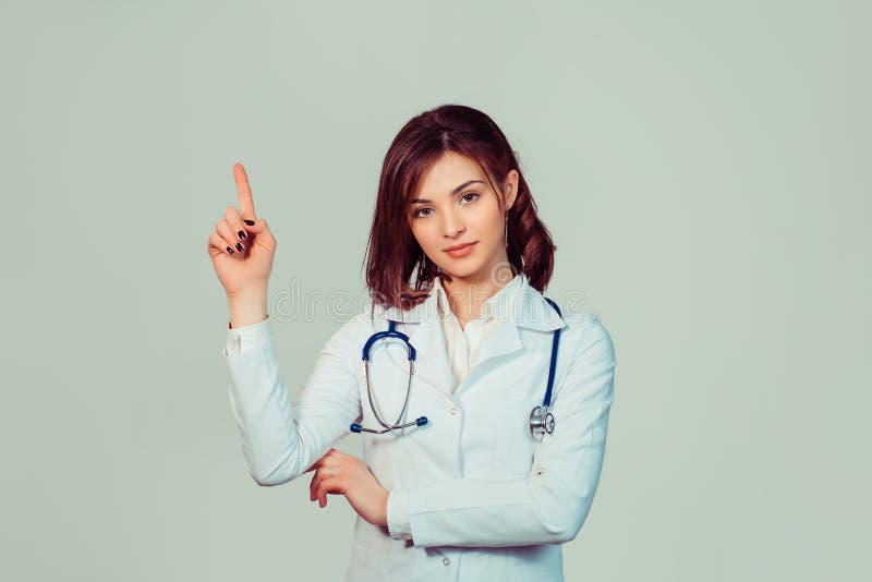 Confident female doctor. Cheerful healthcare professional pointing away stock photo Confident female doctor. Cheerful healthcare professional pointing away stock photo