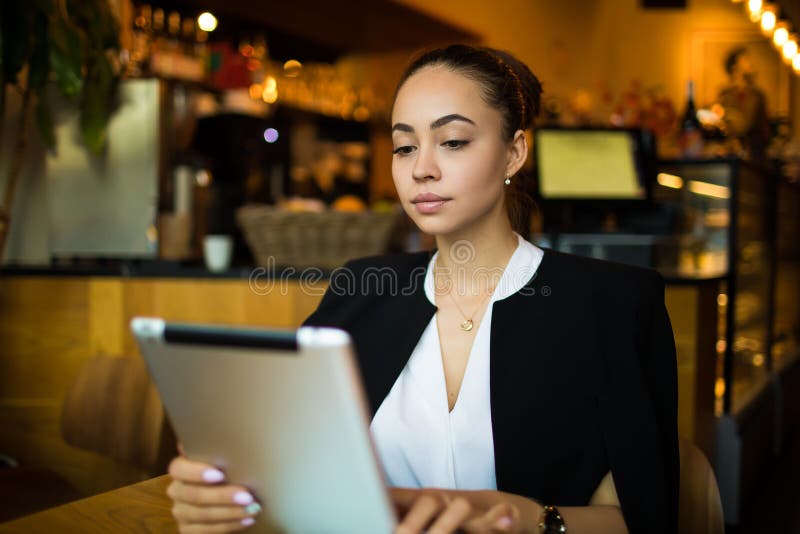 Confident female manager reading financial news via digital tablet. Online banking stock photography Confident female manager reading financial news via digital tablet. Online banking stock photography