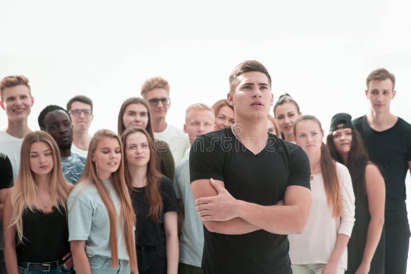 Confident guy standing in front of a casual group of young people. stock image