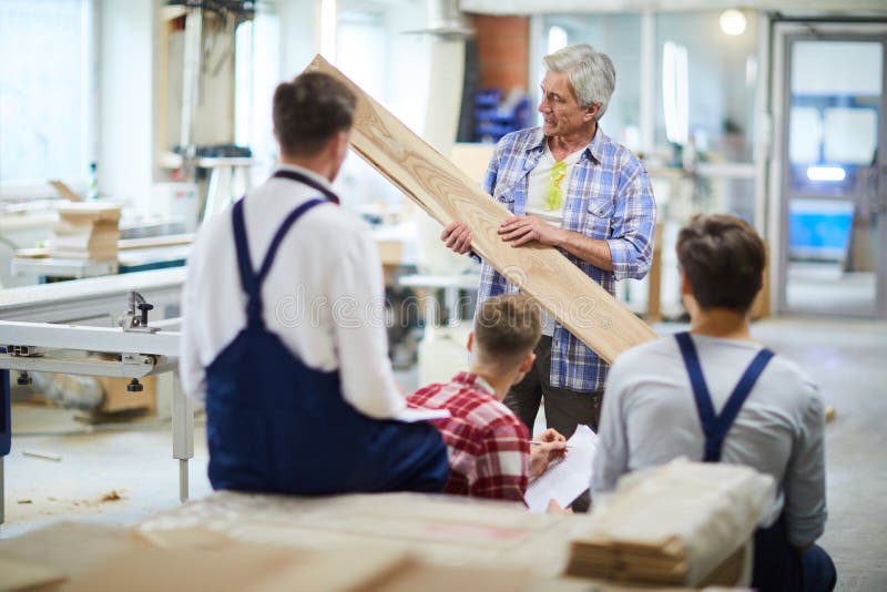 Confident carpenter teaching students to process wood royalty free stock image Confident carpenter teaching students to process wood royalty free stock image