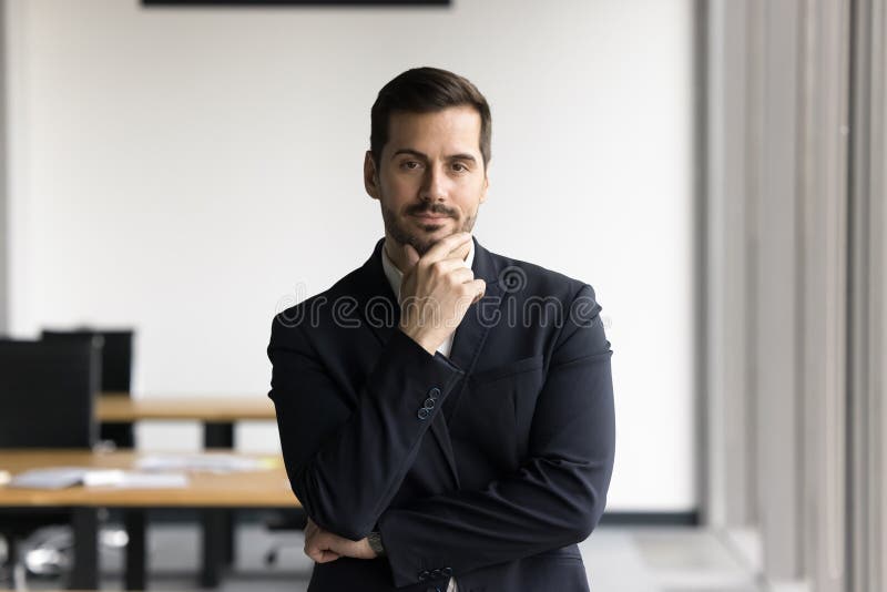 Confident man in business suit standing in office stock photo