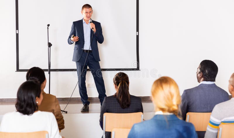Confident man with microphone speaking at corporate business event royalty free stock photos