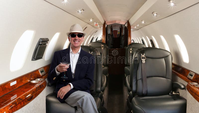 Confident man sitting at his seat in private airplane and smiling stock photos Confident man sitting at his seat in private airplane and smiling stock photos