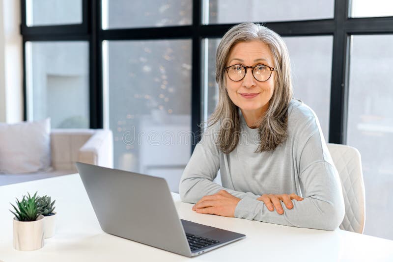 Confident mature female manager ceo sitting at desk indoor royalty free stock photos