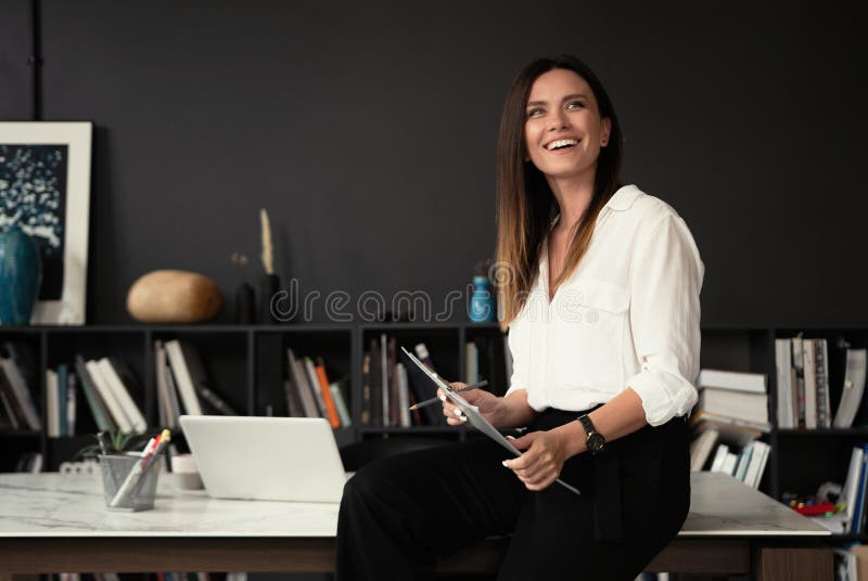 Confident stylish european middle aged woman standing at workplace, 30s lady executive leader manager looking at camera stock photography Confident stylish european middle aged woman standing at workplace, 30s lady executive leader manager looking at camera stock photography