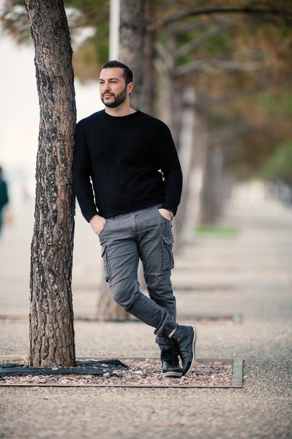 Confident Tough Handsome Man Posing, Leaning Against a Tree Stock Photo ...