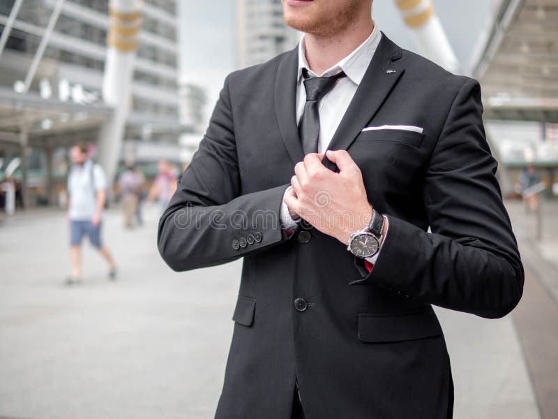 Confident young businessman looking away while standing outdoors with cityscape in the background stock photos Confident young businessman looking away while standing outdoors with cityscape in the background stock photos