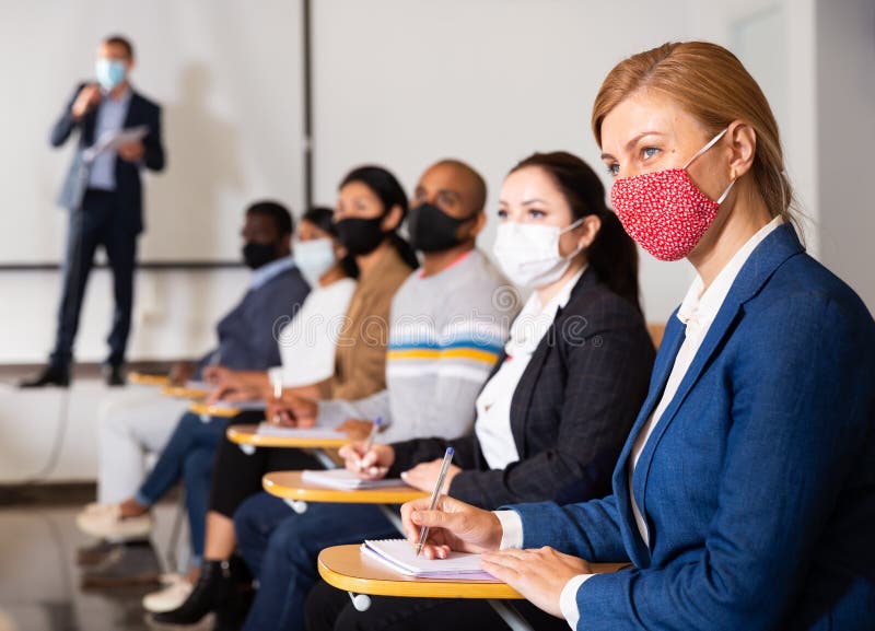 Confident businesswoman in protective mask attending business seminar stock images