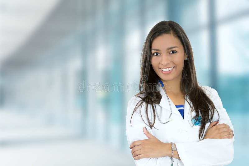 Retrato seguro joven una mujer médico profesionalmente de pie sobre el clínica pasillo ventanas.