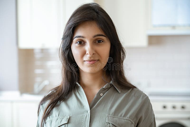 Confident Young Indian Woman Looking At Camera At Home In Kitchen