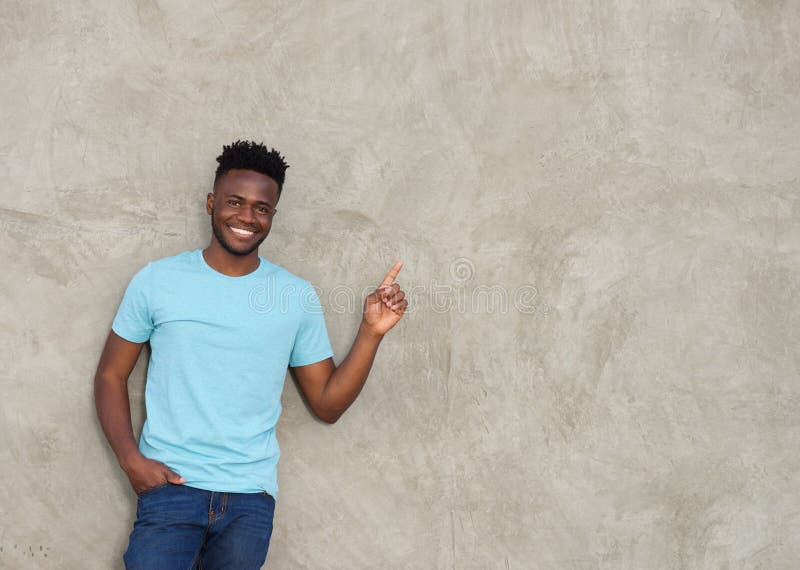 Confident young man pointing and smiling stock images Confident young man pointing and smiling stock images