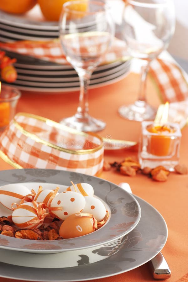 Configuration de table de Pâques dans des sons oranges image stock Configuration de table de Pâques dans des sons oranges image stock