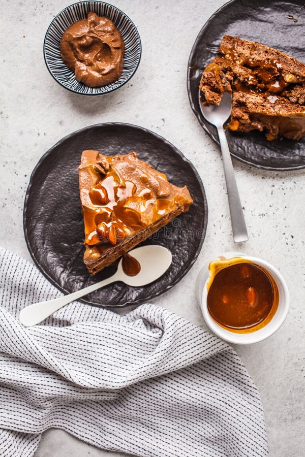 A configuração lisa das partes de risos abafados caseiros endurece com creme do chocolate e caramelo em uns pires pretos, fundo b fotografia de stock A configuração lisa das partes de risos abafados caseiros endurece com creme do chocolate e caramelo em uns pires pretos, fundo b fotografia de stock