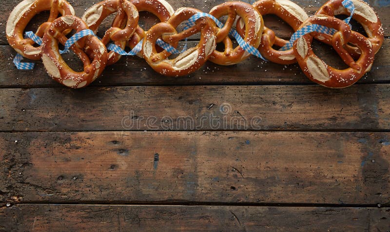 Border of traditional German pretzels on dark aged wood background with copy space for your Oktoberfest themed text. Border of traditional German pretzels on dark aged wood background with copy space for your Oktoberfest themed text