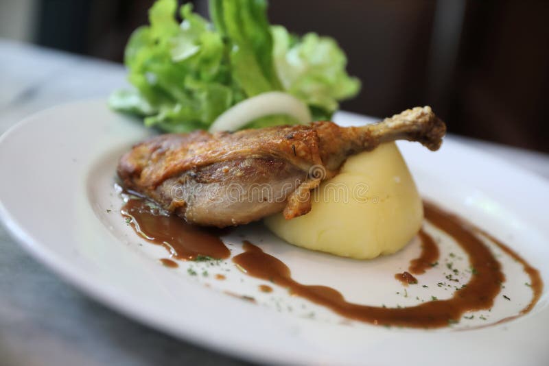 Confit de tidningsanka på en platta, andconfit med grönsaken royaltyfria bilder Confit de tidningsanka på en platta, andconfit med grönsaken royaltyfria bilder