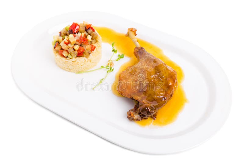 Confit утиной ножки с кускус и овощами стоковое фото Confit утиной ножки с кускус и овощами стоковое фото