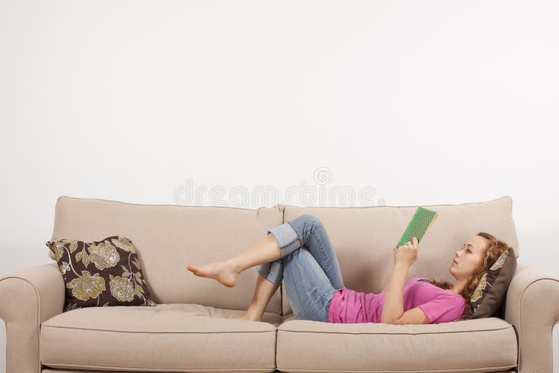 Confortavelmente lendo um livro imagem de stock Confortavelmente lendo um livro imagem de stock