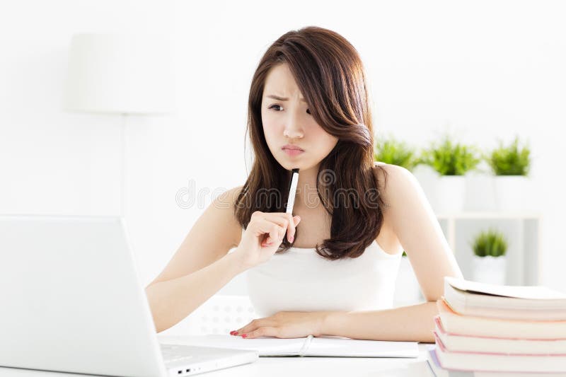 Confused female student studying with laptop royalty free stock images