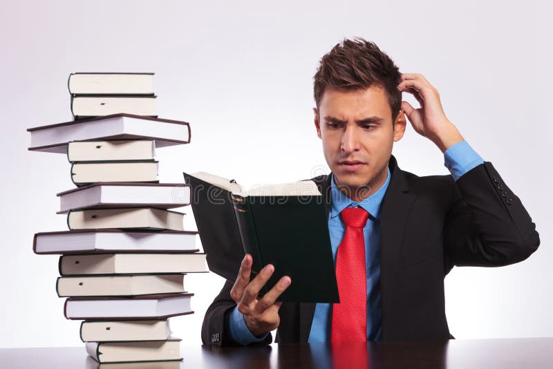 Confused man reading at desk royalty free stock photo
