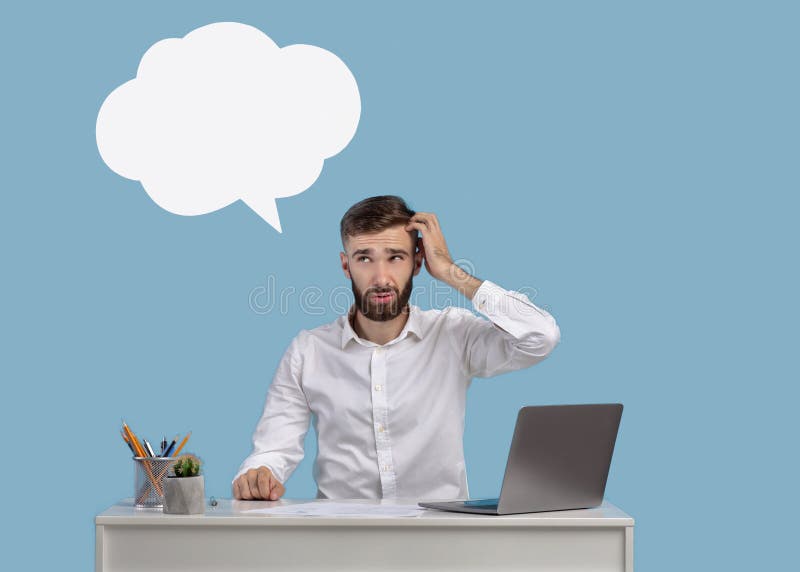 Confused millennial guy with word cloud above his head sitting at desk with laptop, blue background, mockup for design stock images