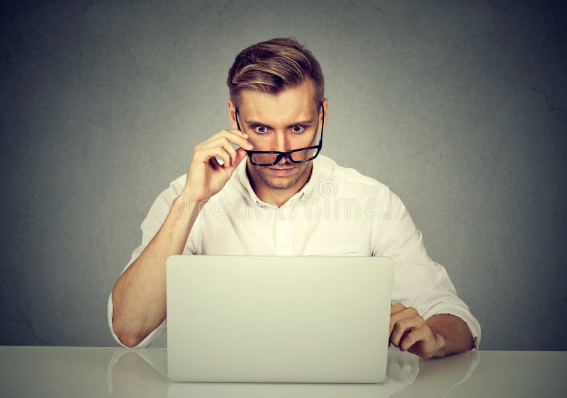 Confused shocked man looking at his laptop