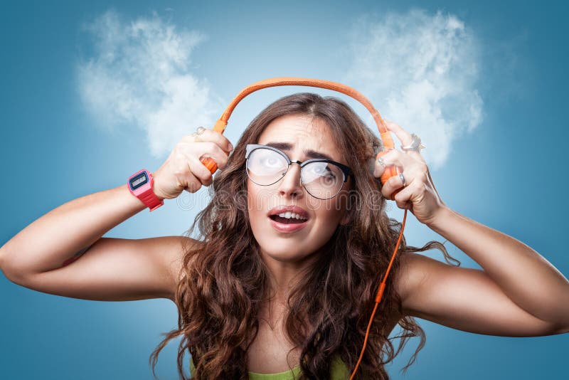 Confused surprised girl in headphones listening to music.