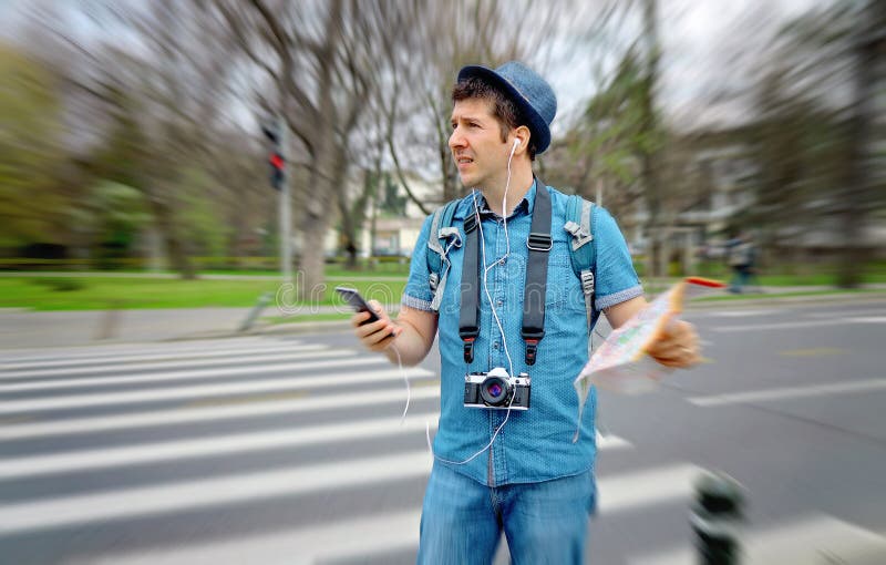 Confused tourist on the streets in a touristic destination - Tourist on the street looking at a map - Lost male tourist holding a royalty free stock image Confused tourist on the streets in a touristic destination - Tourist on the street looking at a map - Lost male tourist holding a royalty free stock image