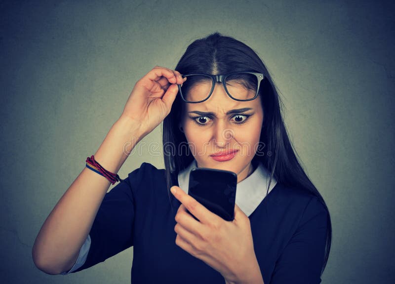 Confused woman with glasses having trouble seeing cell phone