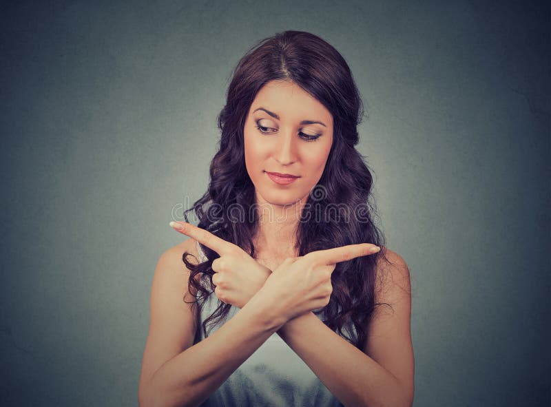Confused woman pointing in two different directions. Confused young woman pointing in two different directions not sure which way to go in life. Human emotion stock photo Confused woman pointing in two different directions. Confused young woman pointing in two different directions not sure which way to go in life. Human emotion stock photo