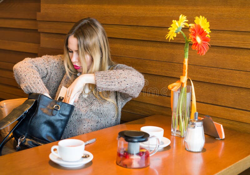 Confused woman searching something in her bag.