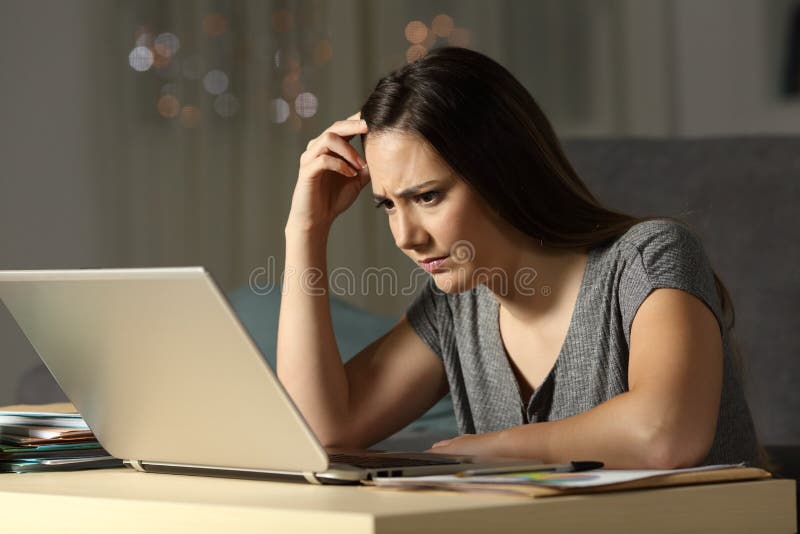 Confused woman working online late hours