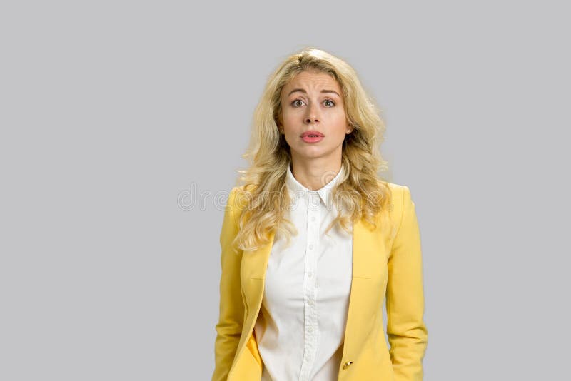 Confused young woman, grey background. stock photos Confused young woman, grey background. stock photos