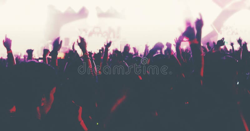 Confuso delle siluette della folla di concerto alla retrovisione della folla di festival sollevare le loro mani sulla fase lumino fotografie stock Confuso delle siluette della folla di concerto alla retrovisione della folla di festival sollevare le loro mani sulla fase lumino fotografie stock