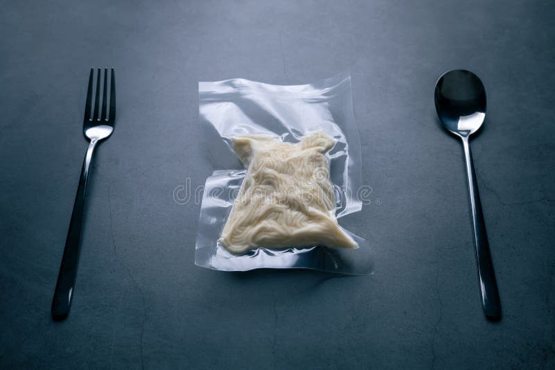 Freeze cooked spaghetti or noodles in vacuum pack with spoon and fork on grunge table, concept of food preservation, good work from home lunch idea, pity food for easily justify eating on bysy day. Freeze cooked spaghetti or noodles in vacuum pack with spoon and fork on grunge table, concept of food preservation, good work from home lunch idea, pity food for easily justify eating on bysy day