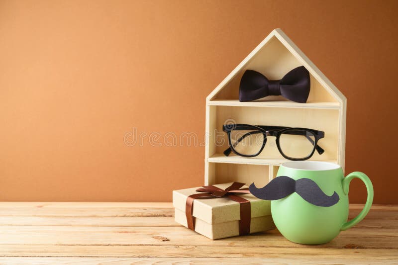 Happy  Fathers day concept with green coffee cup, toy house and gift box on wooden table. Happy  Fathers day concept with green coffee cup, toy house and gift box on wooden table
