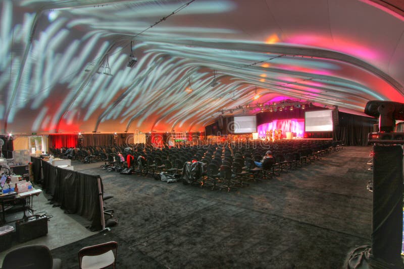 A large group of 800 people general theatre style seating set inside a tent. A large group of 800 people general theatre style seating set inside a tent