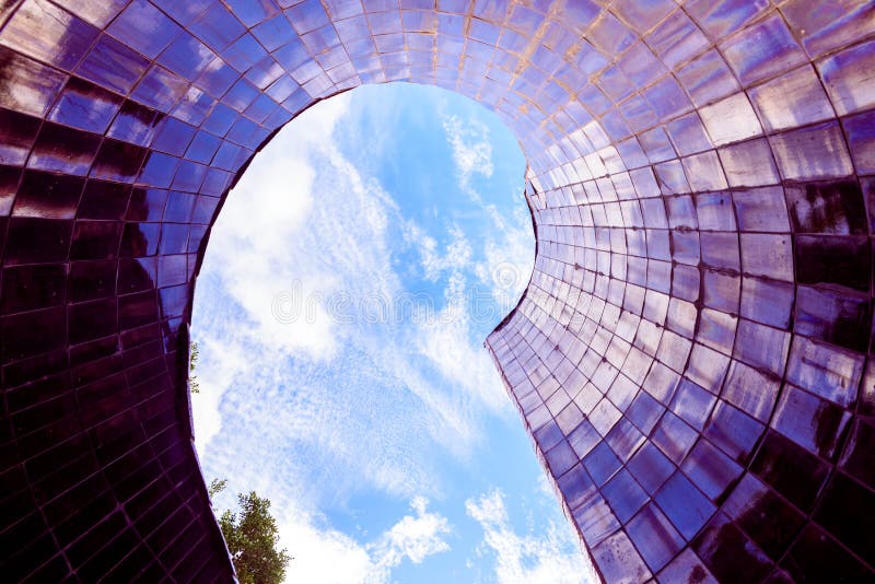 Conical smooth tile surface pointing to the blue sky with reflections of an abstract background stock images