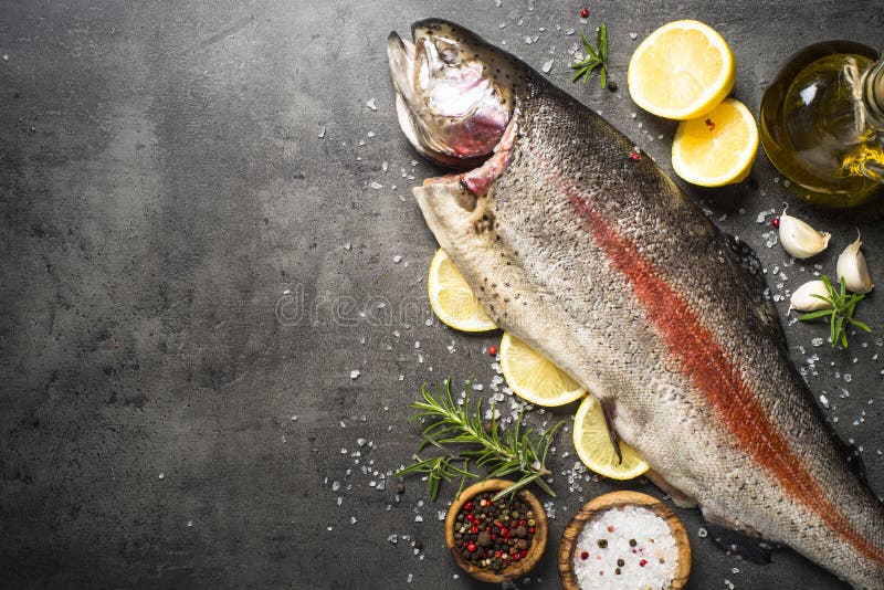 Conjunto de color salmón crudo de los pescados con los ingredientes para los cookings en negro fotografía de archivo libre de regalías Conjunto de color salmón crudo de los pescados con los ingredientes para los cookings en negro fotografía de archivo libre de regalías