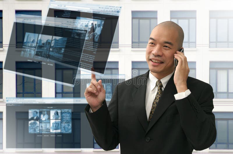 Oriental looking bald business man on phone and internet. Oriental looking bald business man on phone and internet