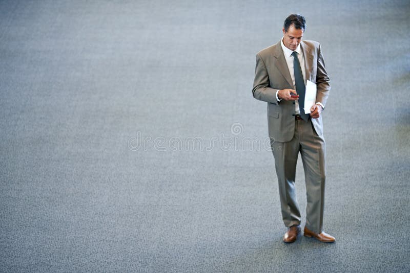 Connected anywhere you find yourself. Full length shot of a businessman reading a text message. stock photography