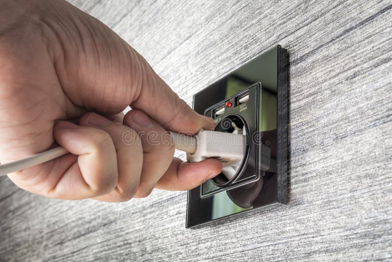Connecting To the Power Supply on the Wall from an Outlet. Hand Putting