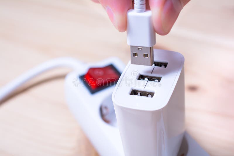 Connecting A White USB Cable To A White USB Charger Which Is Plugged Into A Power Strip stock photo Connecting A White USB Cable To A White USB Charger Which Is Plugged Into A Power Strip stock photo
